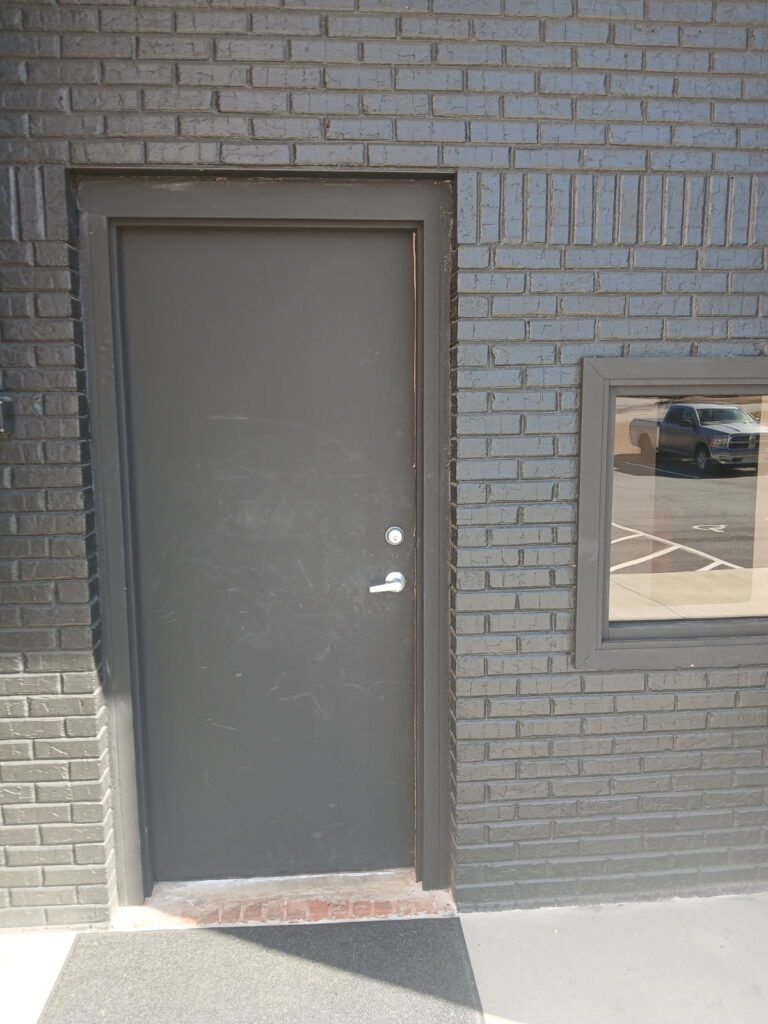 Fire door repair completed on a commercial metal entry door.
